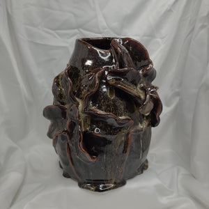 Handbuilt using the coiling method. Medium sized vase with lily-like petals. Brown with a hint white glaze using a dipping technique which has created a drizzle effect to include small attached pouddles of glaze at the foot. 